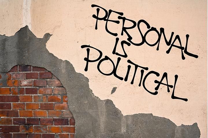 Una pared rota, que en una parte está pintada y en la otra tiene ladrillos. Sobre uno de los costados, un grafiti dice «Lo personal es político» en inglés.