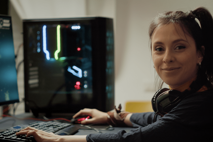 Mujer jugando en su ordenador sonríe mirando a la cámara